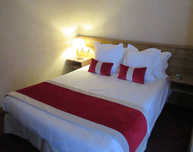 lampe de chevet allumée près d'un lit dans une chambre d'hôtel